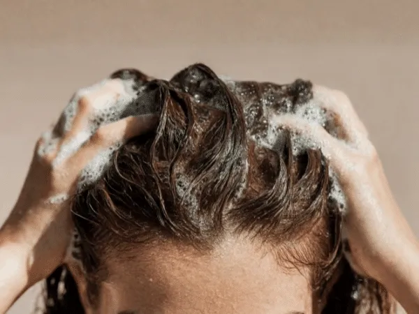 Lavaggio dei capelli con shampoo delicato e massaggio del cuoio capelluto