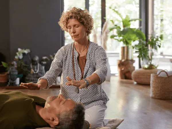 Pranoterapeuta che pratica un trattamento energetico senza contatto, mostrando come funziona la pranoterapia, cosa fa il pranoterapeuta e come il curare con le mani viene applicato nella pratica.